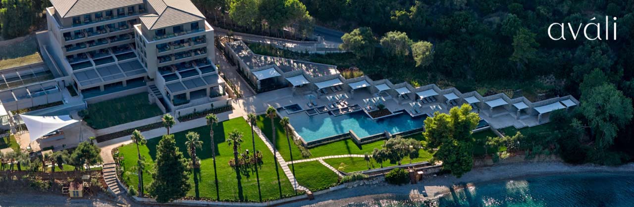 A view from above showing the main building of the MarBella Avali Hotel and the row of bungalow suites alongside the clear blue swimming pool